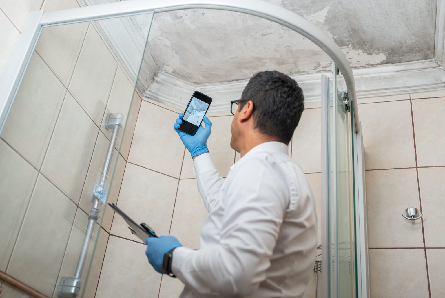 a mold inspector taking picture of mold on the bathroom roof.